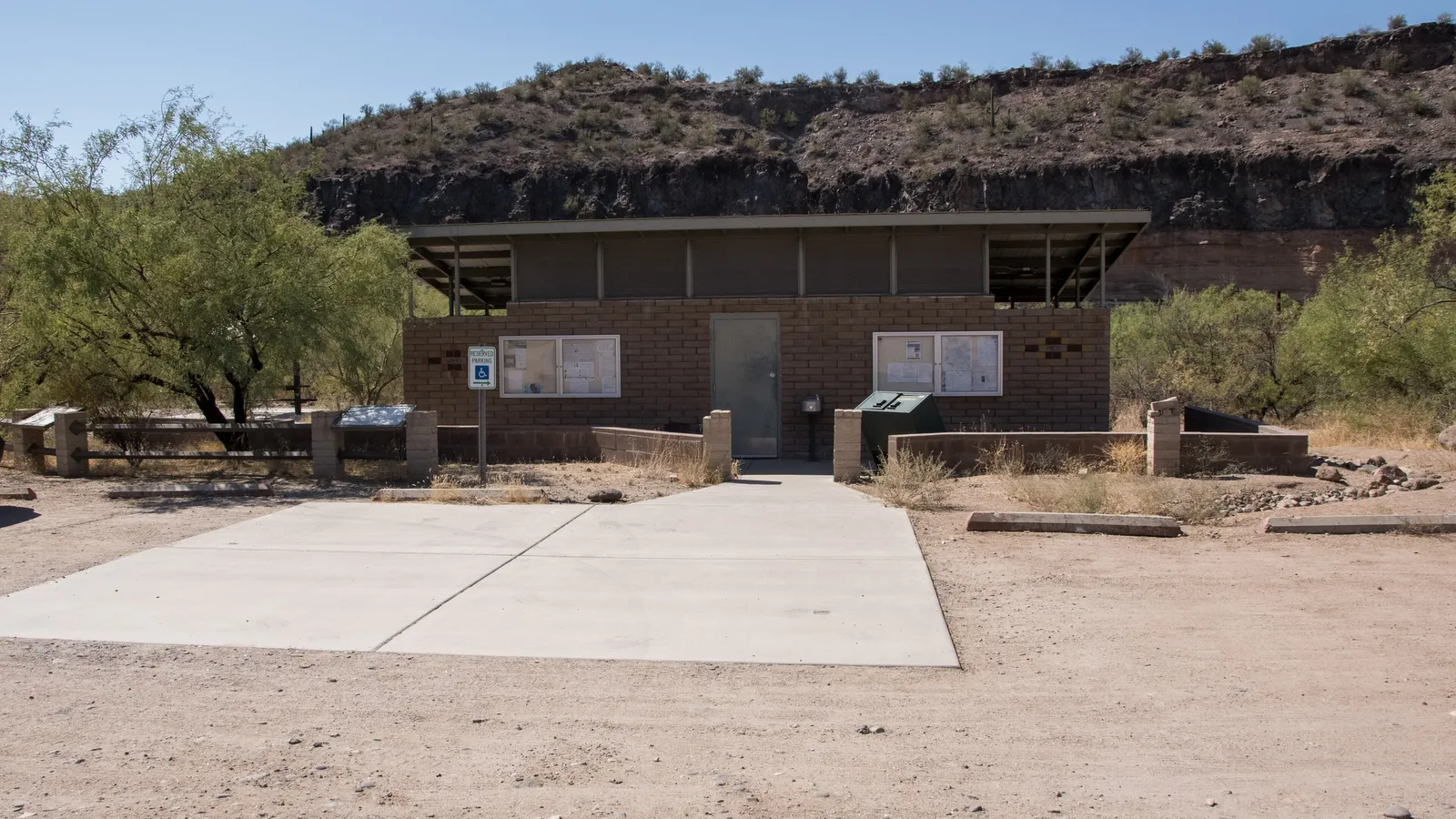 Finished concrete pad with control joints in front of a small block building