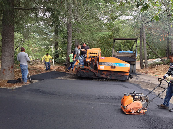 Rich's Paving crew at work in Santa Rosa Richs' Paving Contractors crew paving a driveway in wooded area in Santa Rosa